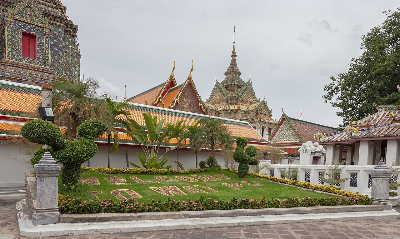 ลานวัดโพธิ์ กรุงเทพฯ — แนวเจดีย์กระเบื้องเคลือบสี หลังคาวิหาร และสวนไม้ดัดหน้าทางเข้า