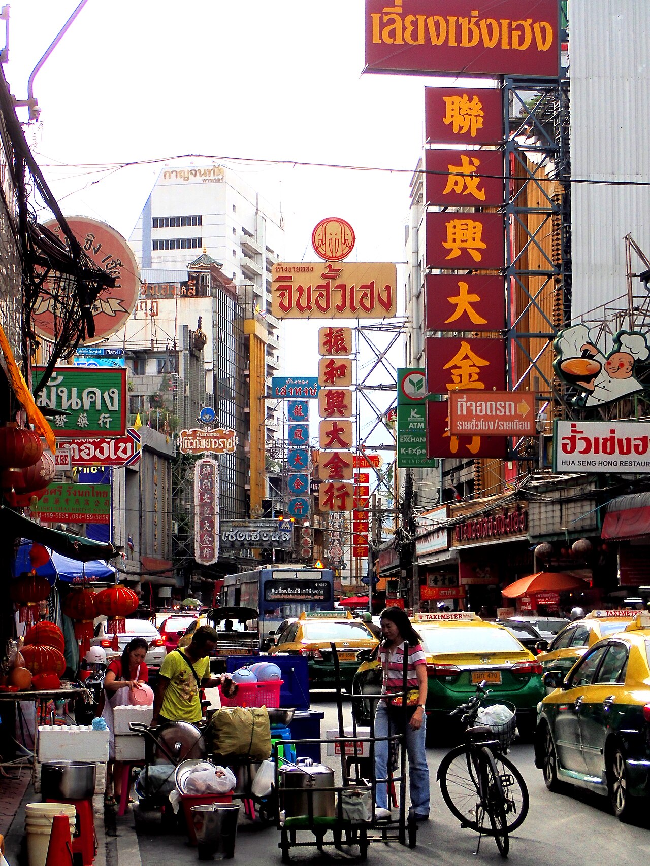 เยาวราช กรุงเทพฯ — ถนนไชน่าทาวน์เต็มไปด้วยป้ายร้านภาษาจีน แท็กซี่ และรถเข็นริมทาง