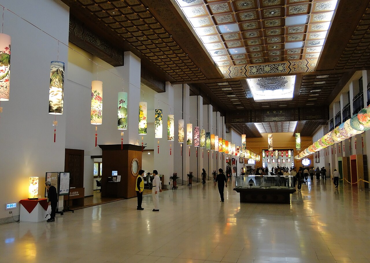 The lower-floor exhibition gallery of the Chiang Kai-shek Memorial Hall, Taipei — a wide high-ceilinged hall hung with cylindrical lanterns and artworks
