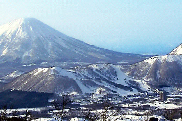 Rusutsu Resort ski runs cutting through forest in Hokkaido with Mt Yotei in the background