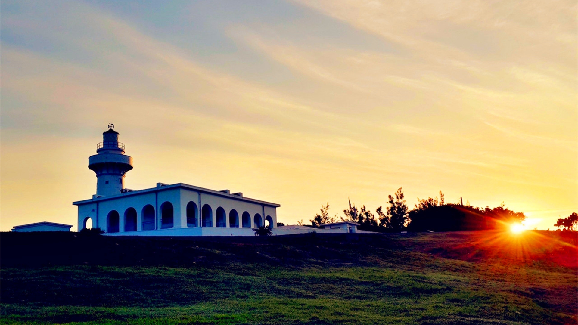 Eluanbi Cape lighthouse and rocky shoreline at Kenting golden hour sunset