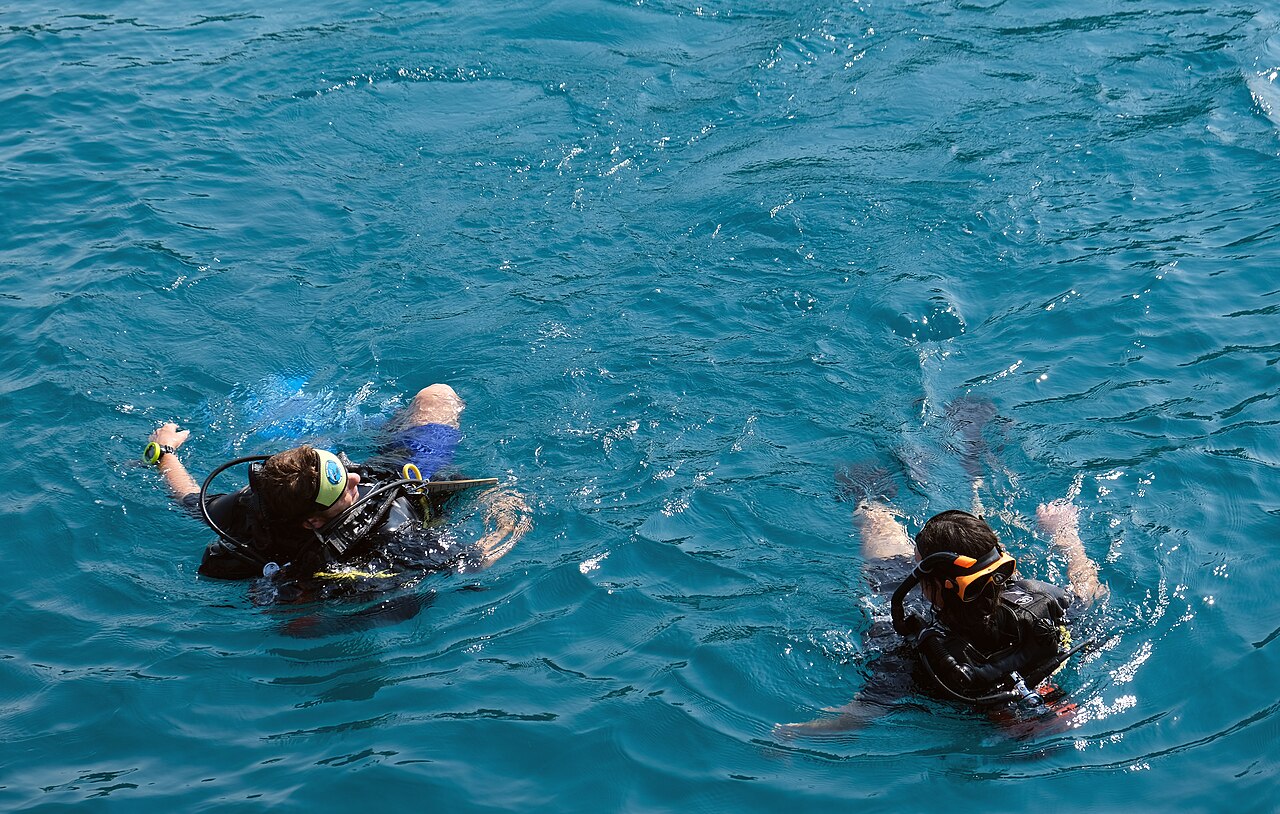 Two snorkellers floating in clear blue water at Koh Rang in the Mu Ko Chang National Park, wearing masks and snorkels to watch the coral from the surface