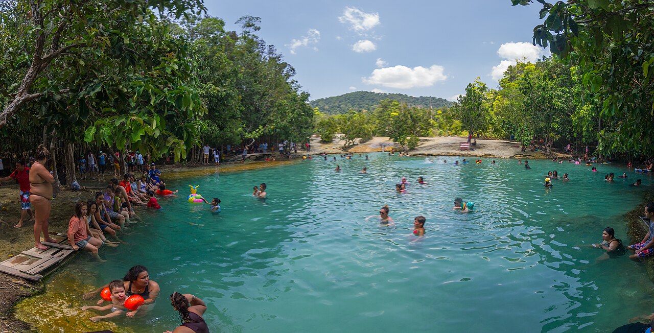 Emerald Pool Krabi — a clear jade-green natural pool in the rainforest with people swimming and green trees all around