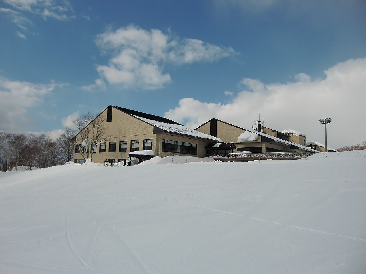 อาคารฐานลาน Annupuri ของ Niseko ท่ามกลางหิมะหนาใต้ท้องฟ้าสีฟ้า