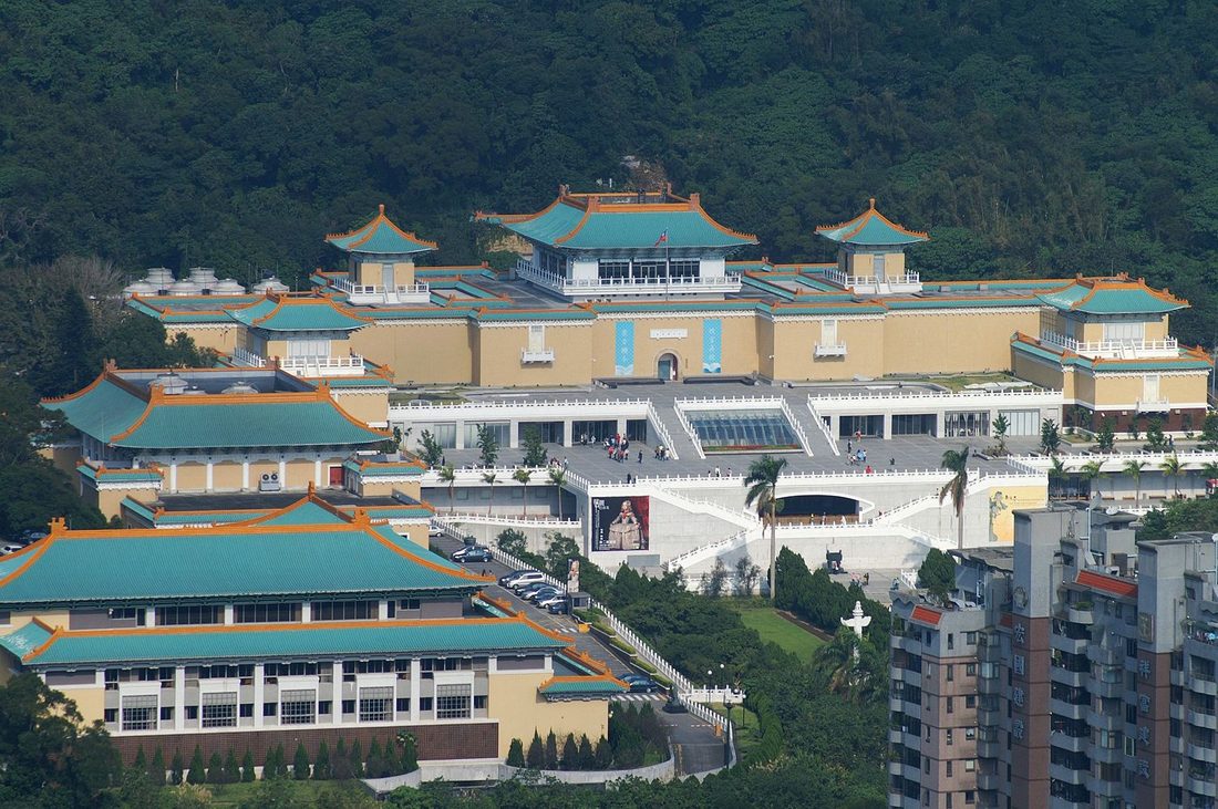 The National Palace Museum building in Taipei set against lush green hills