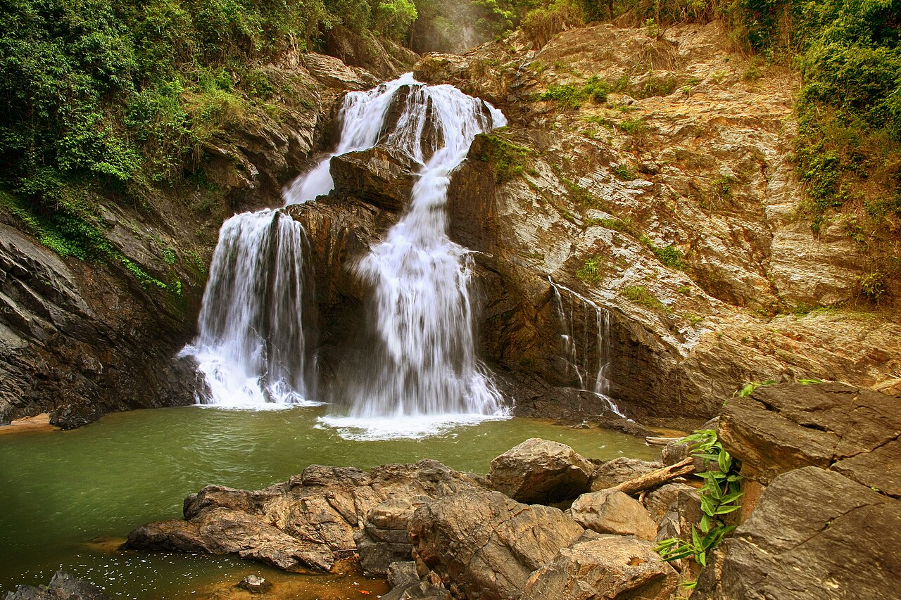 น้ำตกกรุงชิง อุทยานแห่งชาติเขาหลวง นครศรีธรรมราช — น้ำตกหลายชั้นไหลผ่านโขดหินลงสู่แอ่งน้ำสีเขียวกลางป่า
