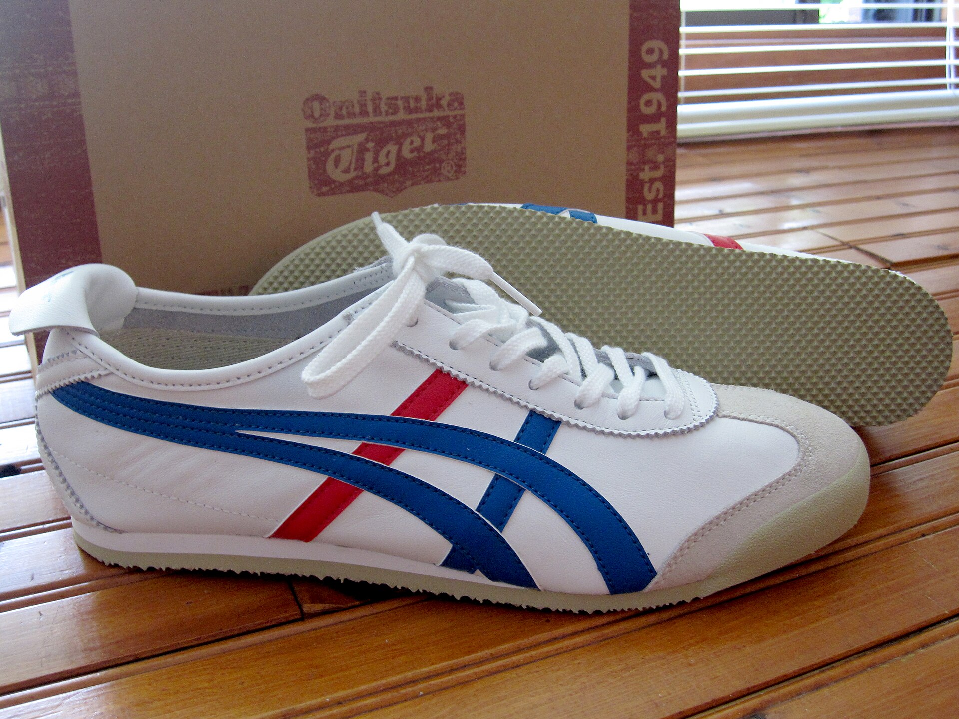 รองเท้า Onitsuka Tiger Mexico 66 สีขาวแถบน้ำเงิน-แดงคลาสสิก วางคู่กับกล่องแบรนด์