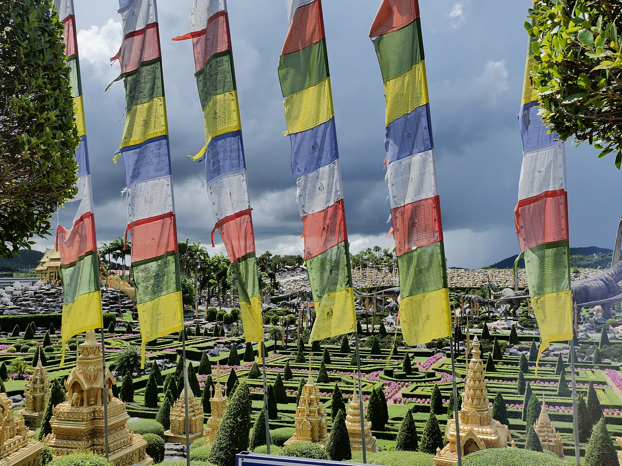 สวนธีมแบบภูฏานในสวนนงนุชพัทยา — มีธงมนตราหลากสีและงานสถาปัตยกรรมตกแต่งในพื้นที่สวน