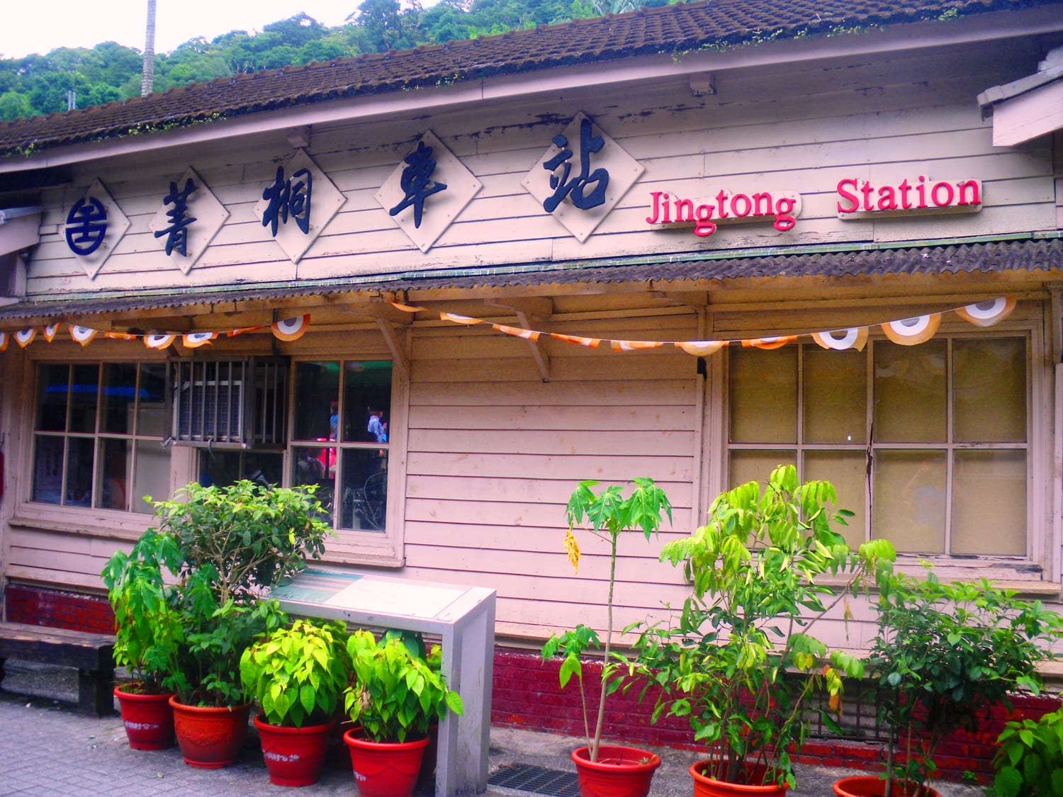 The old wooden Jingtong railway station from the Japanese colonial era on the Pingxi Line, with red flowerpots lined up out front