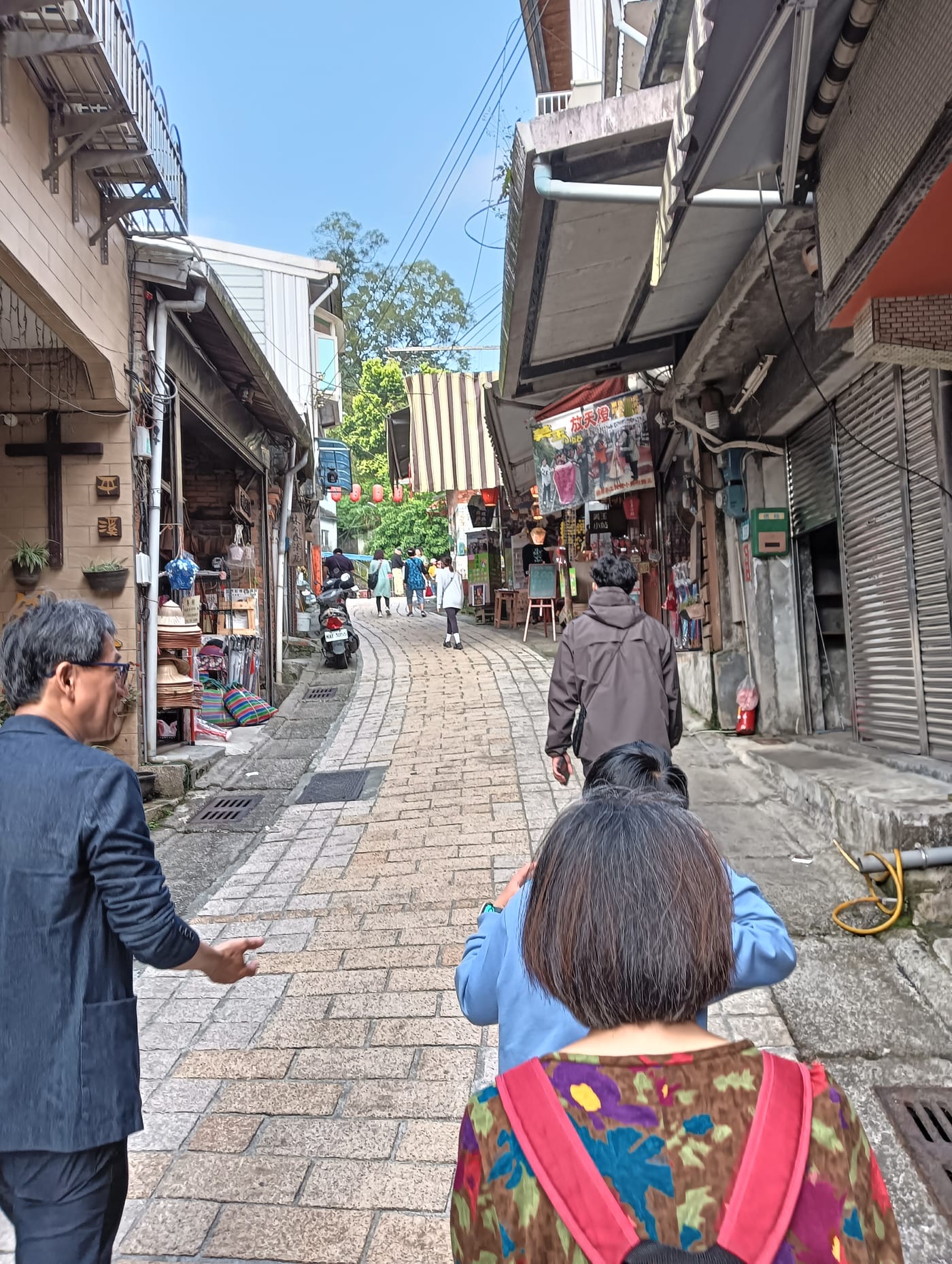Pingxi Old Street on a hillside, with old houses on both sides and visitors walking on the stone-paved lane in Pingxi District, New Taipei