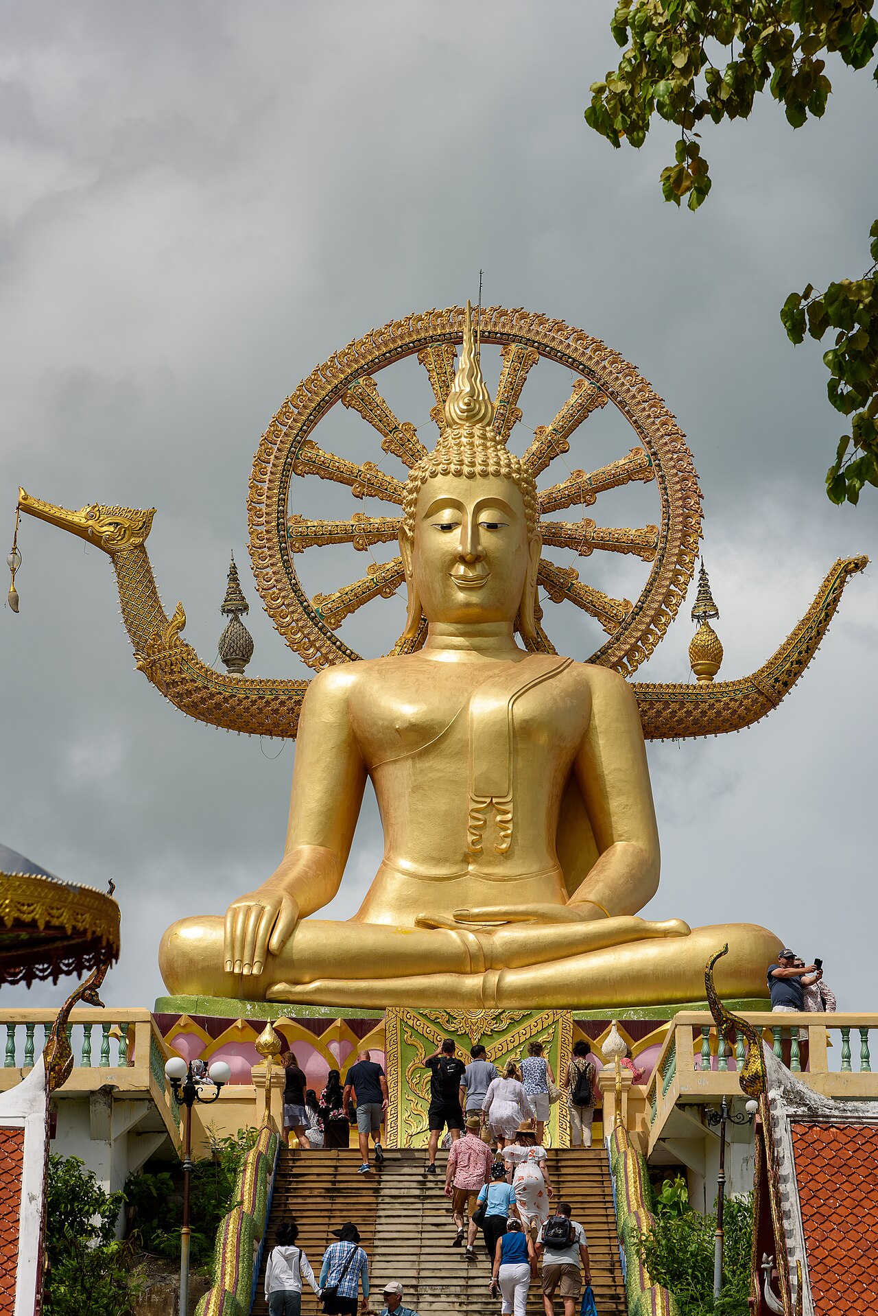 พระใหญ่เกาะฟาน วัดพระใหญ่ เกาะสมุย — พระพุทธรูปปางมารวิชัยสีทองสูง 12 เมตร มีบันไดทางขึ้นและผู้คนเดินขึ้นไปสักการะ