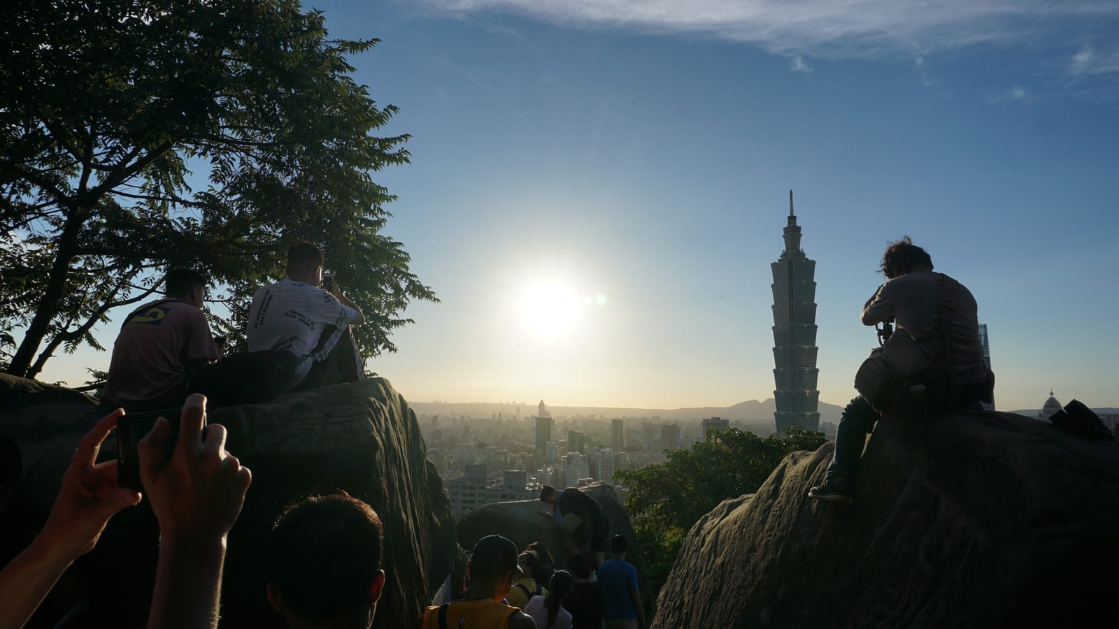 View of Taipei 101 from Elephant Mountain at golden hour with visitors taking photos