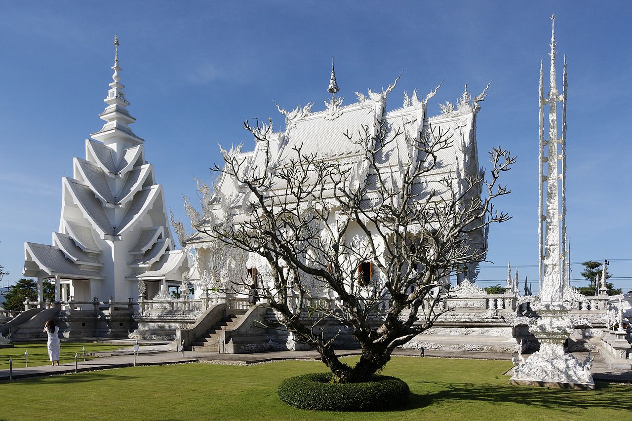 วัดร่องขุ่น (วัดขาว) เชียงราย — โบสถ์สีขาวล้วนประดับกระจกใสเป็นประกาย มีสะพานข้ามทะเลมือด้านหน้า