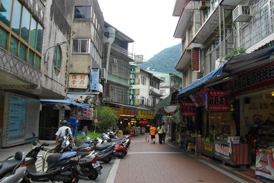 Wulai Old Street (烏來老街), a row of shops and food stalls in the mountain valley with visitors browsing