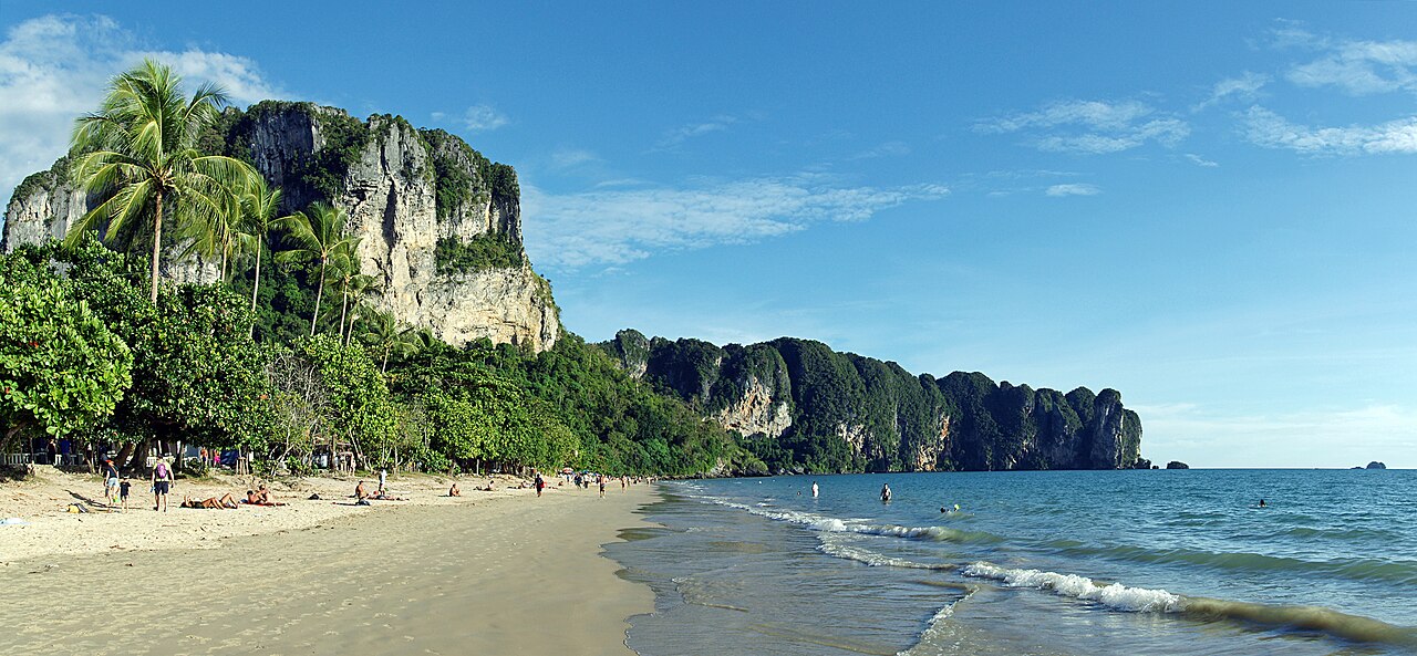 Ao Nang beach in the afternoon — limestone cliffs, coconut palms and the Andaman Sea, Krabi's strolling and boat-launching beach