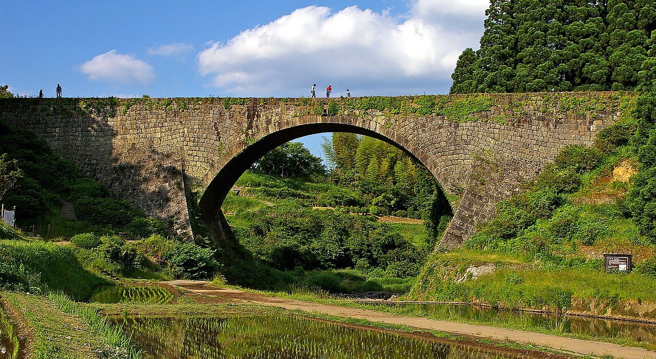 สะพานโค้งหินโบราณ Tsujunkyo ในคุมาโมโตะ แมนน้ำพุ่งออกจากส่วนตรงกลางสร้างภาพสายน้ำตกสวยงาม