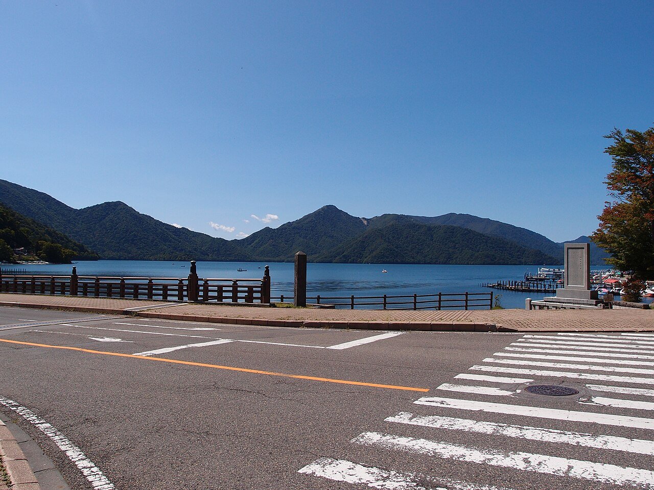 Lake Chuzenji, Nikko — a blue mountain lake at 1,269 metres ringed by green peaks under clear sky