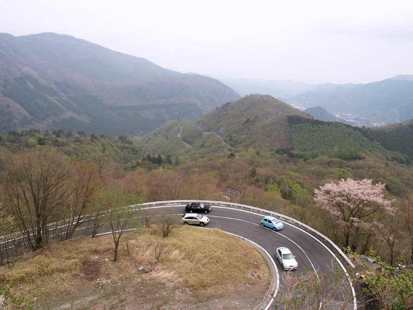 The Irohazaka road in Nikko seen from above, hairpin bends winding up the forested mountain