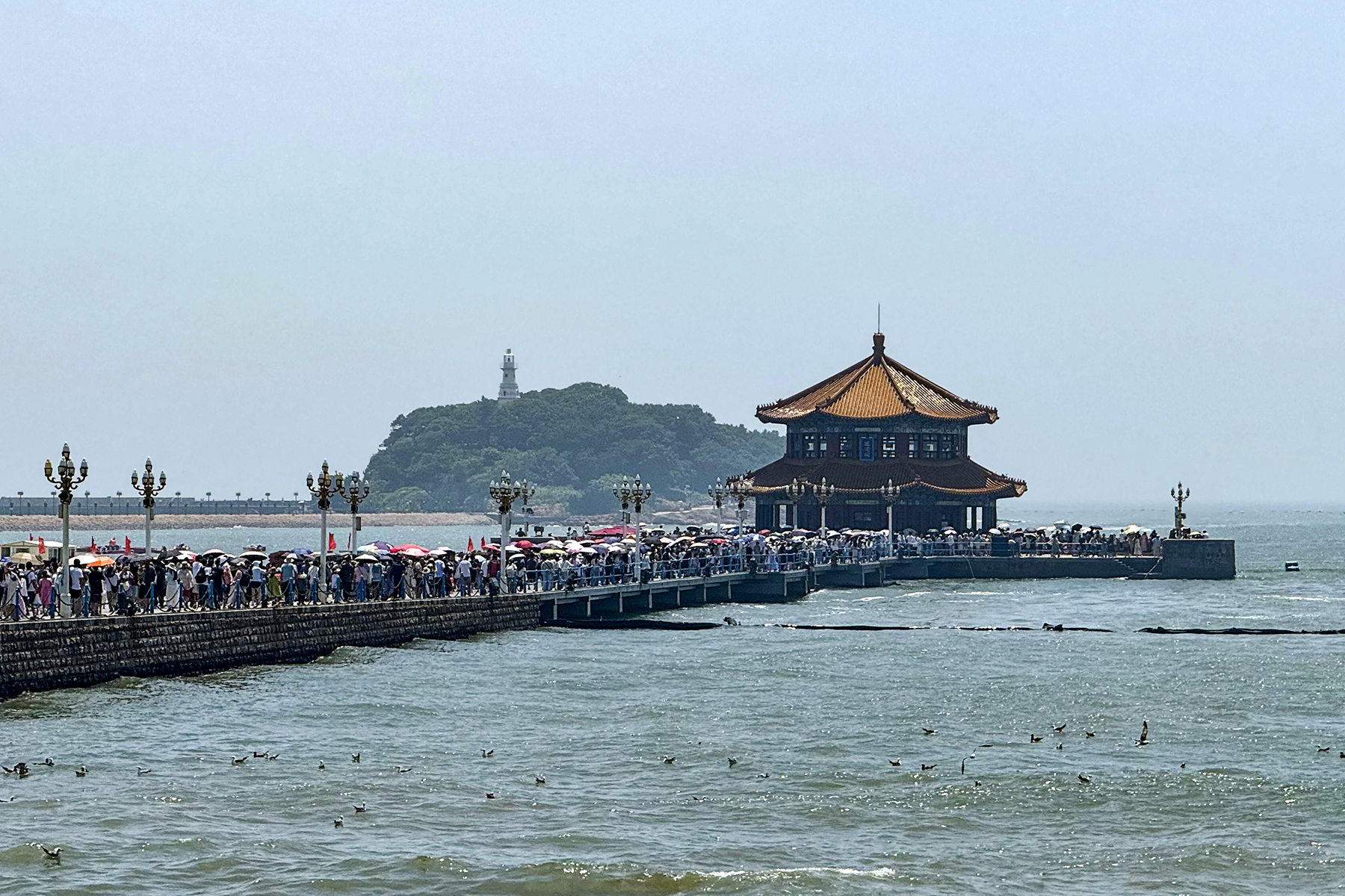 สะพานจ้านเฉียวชิงเต่า — สะพานหินทอดยาวลงทะเลปลายมีศาลาหุยหลานเก๋อหลังคาแดง อยู่ริมเมืองเก่าใกล้มหาวิหารเซนต์ไมเคิล