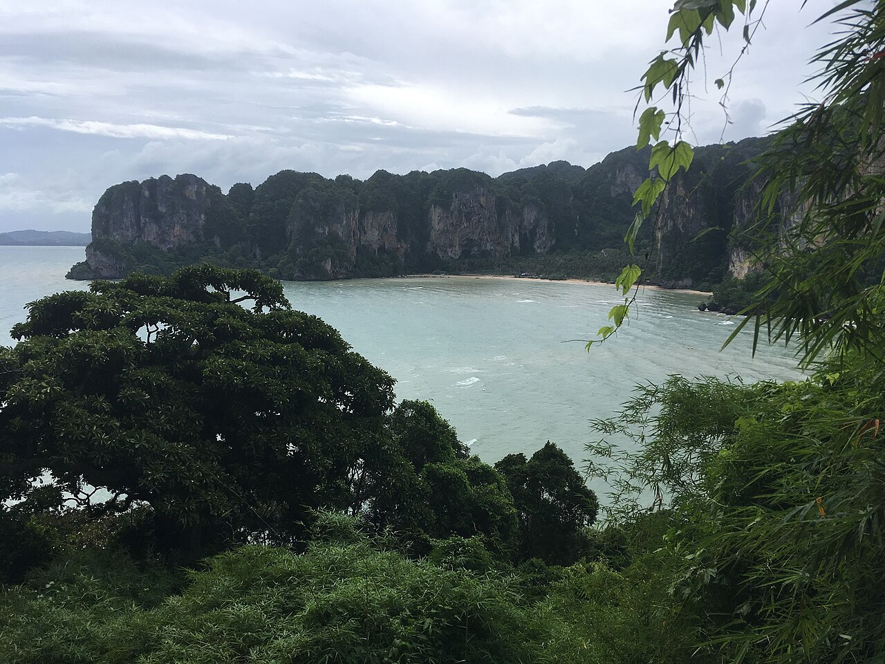ไร่เลย์ฝั่งตะวันออก กระบี่ — อ่าวน้ำสงบล้อมด้วยป่าเขียวและหน้าผาหินปูน บรรยากาศเงียบสงบ