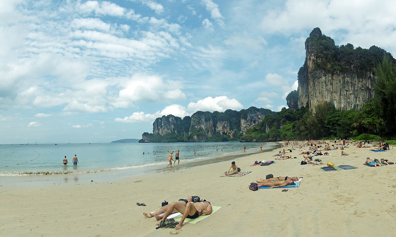 หาดไร่เลย์เวสต์ กระบี่ — หาดทรายขาวกว้างน้ำทะเลใส มีหน้าผาหินปูนสูงและคนนอนอาบแดดริมหาด