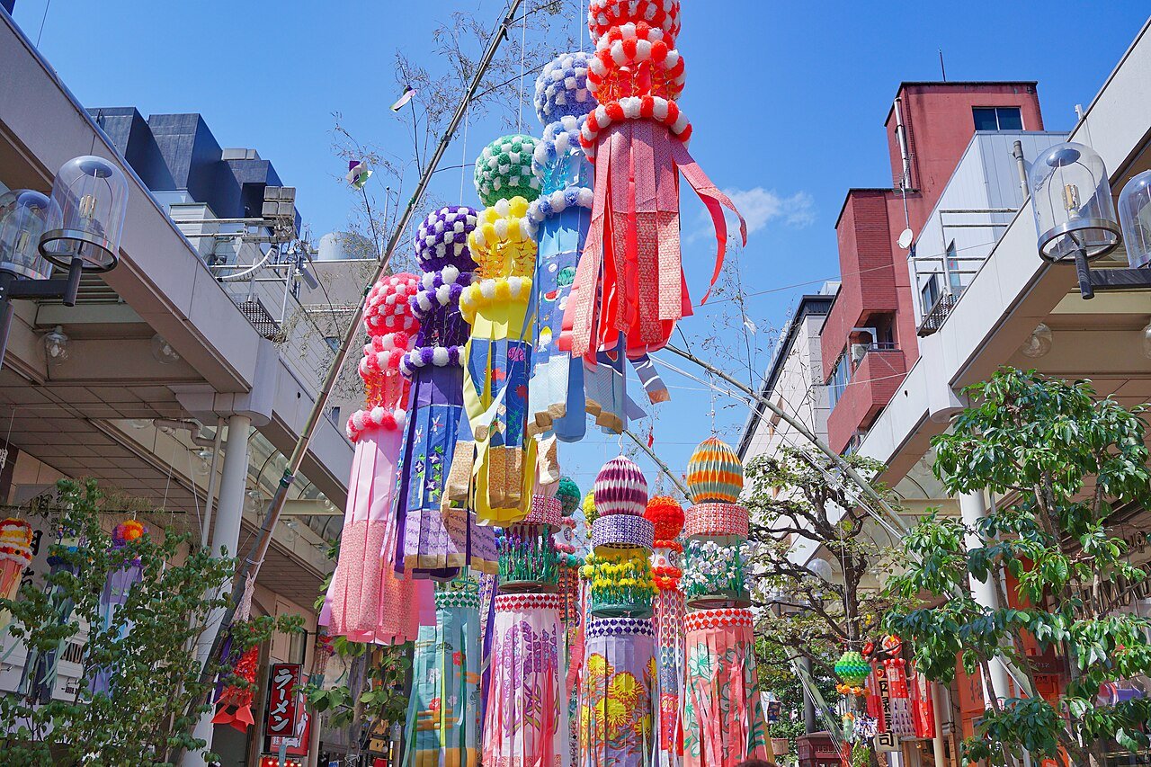 Sendai Tanabata festival streamers — hand-crafted washi paper decorations hanging from bamboo poles inside a covered shopping arcade