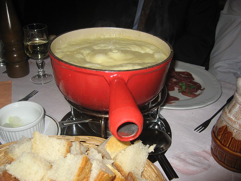 Hot cheese fondue pot with bread on forks