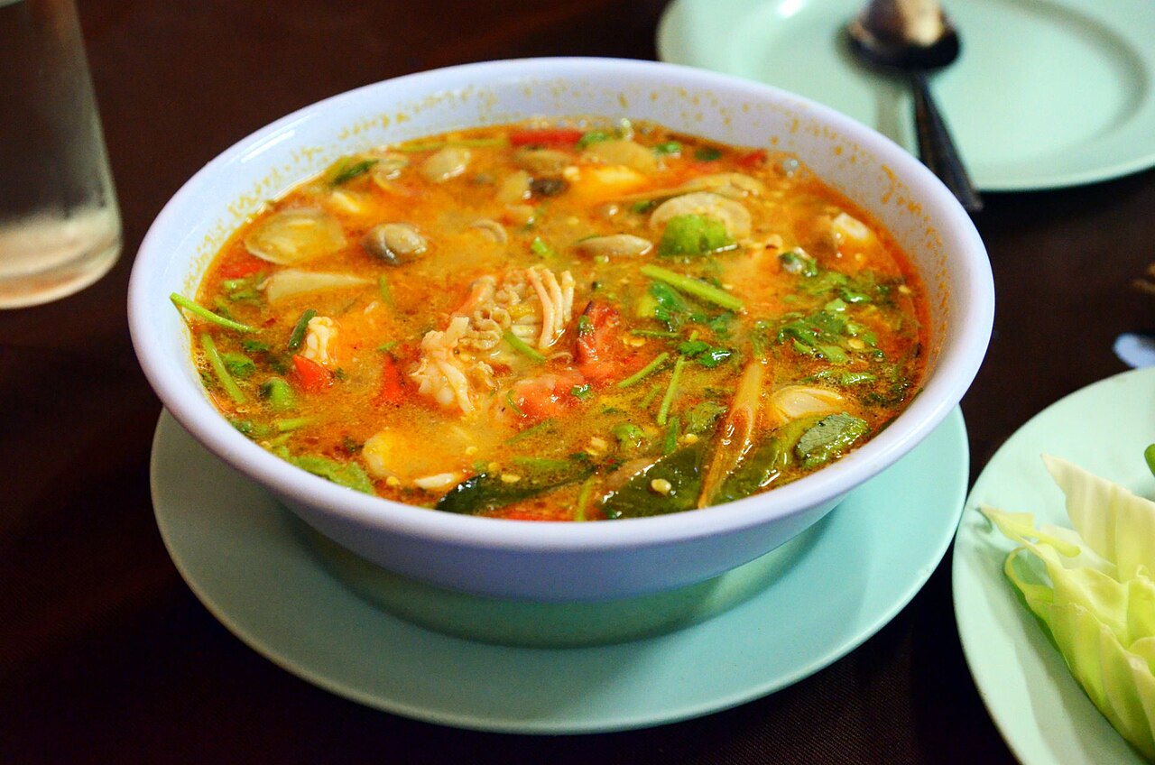 ต้มยำกุ้งน้ำข้น — ซุปสีส้มร้อนๆ ลอยหน้าด้วยกุ้งแม่น้ำ เห็ด ตะไคร้ และใบมะกรูด