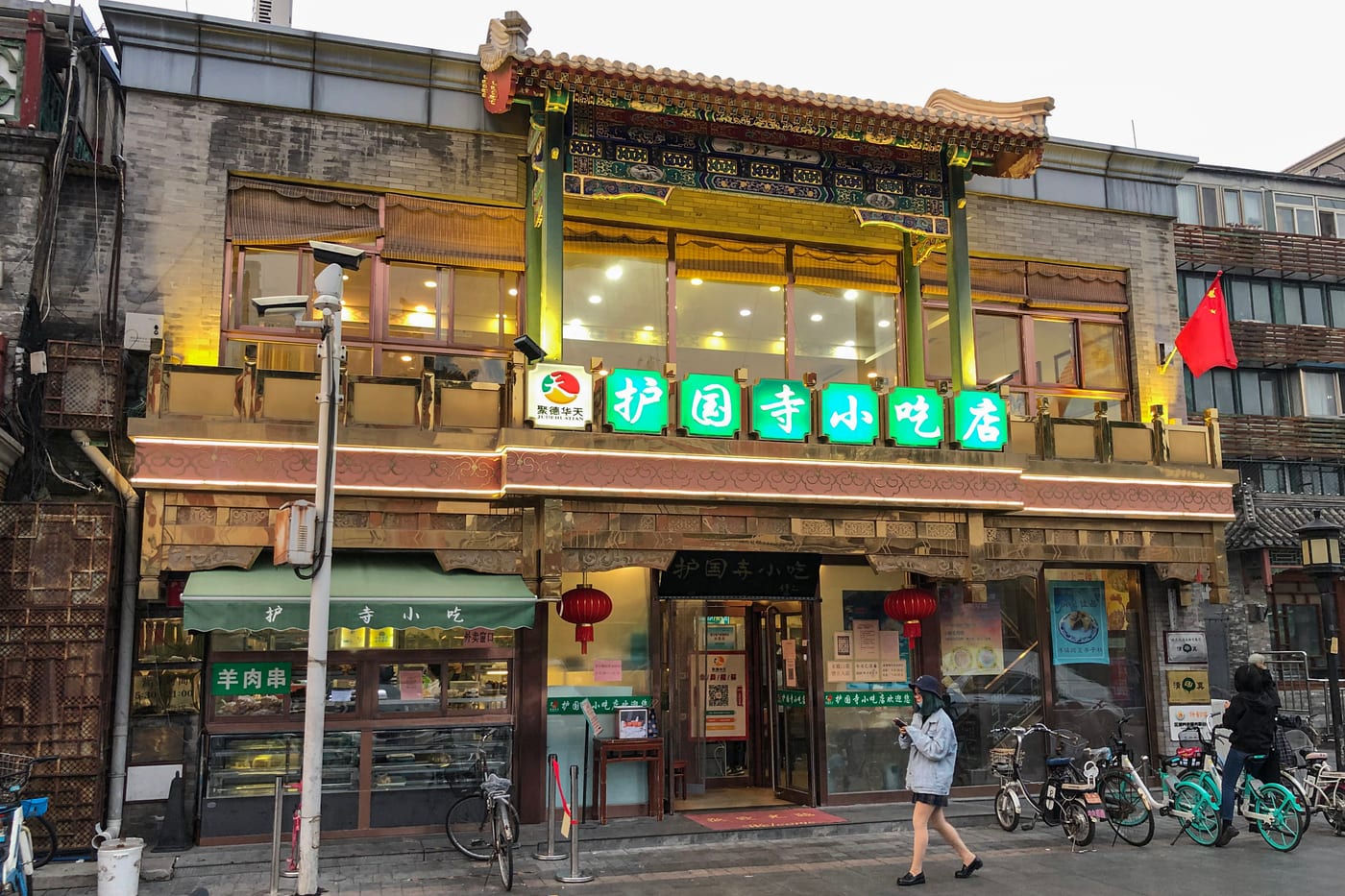 The Huguosi Snacks shopfront (护国寺小吃店) in Beijing — a traditional green-signed counter selling old-Beijing snacks