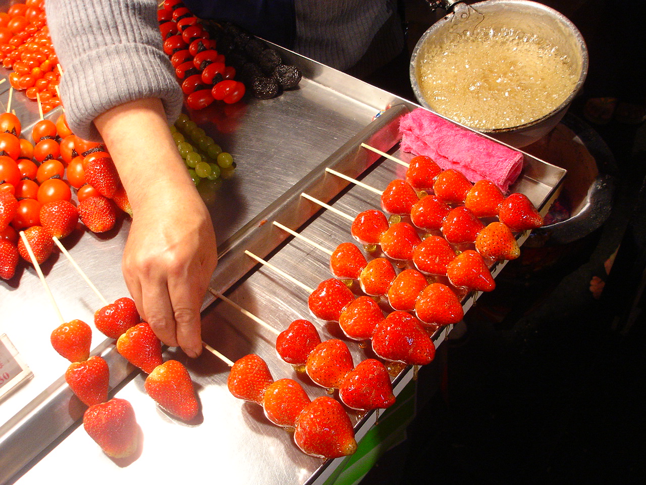 Beijing tanghulu — skewered red hawthorn fruits glazed in clear hard sugar, a glossy street snack