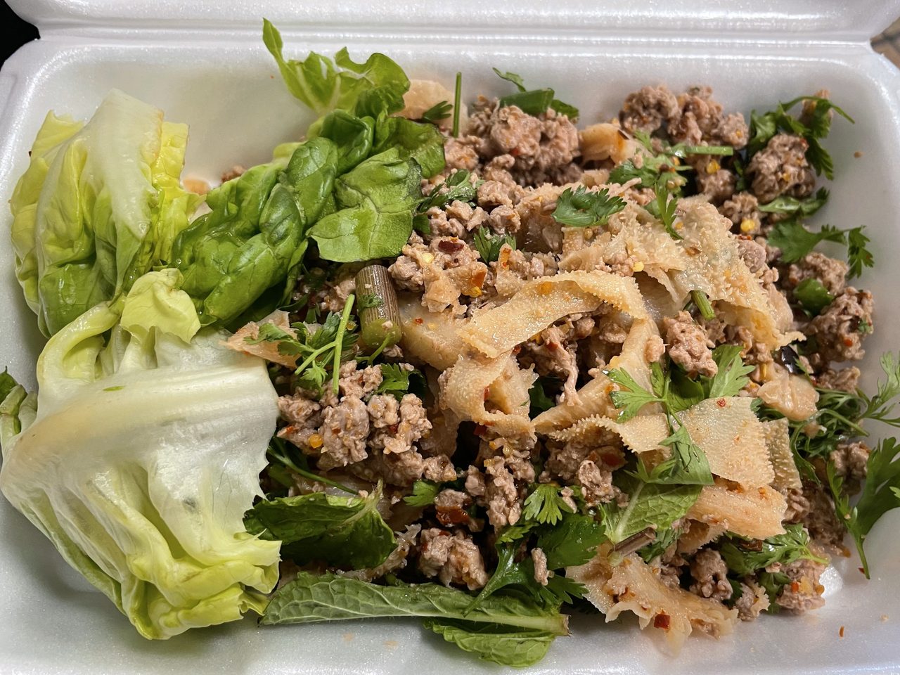 Larb khua mueang — northern-style minced-meat larb dry-fried with offal and herbs, served with fresh vegetables