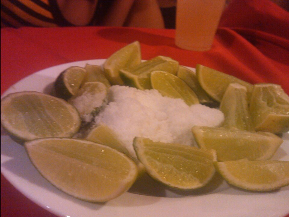 Tequila in a shot glass served with lime and salt