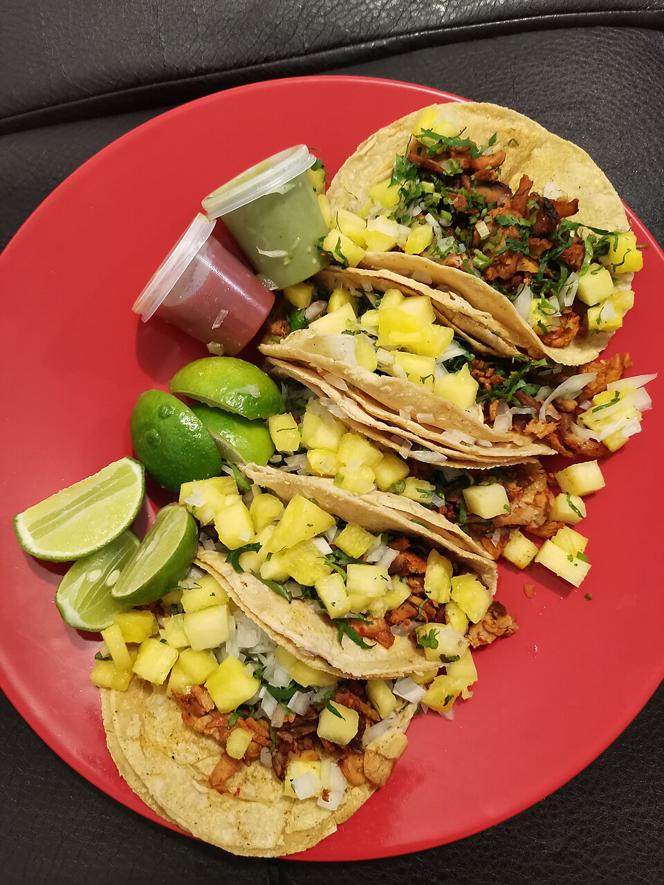 Al pastor tacos with spit-roasted pork topped with pineapple and cilantro
