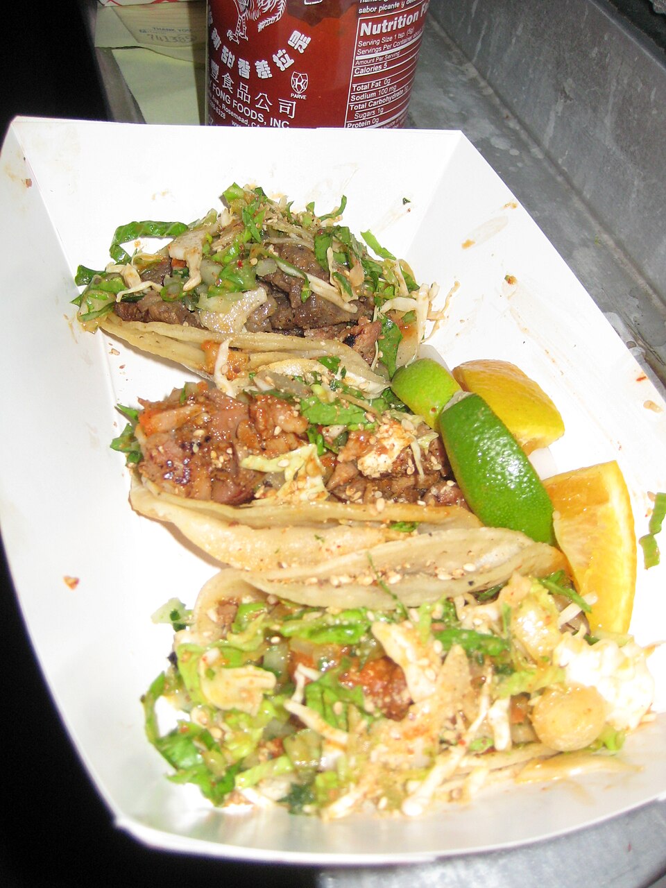 Kogi taco filled with Korean grilled beef topped with pickled vegetables and sauce