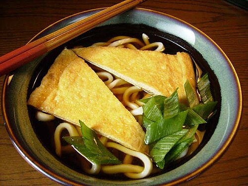 Kitsune udon in a clear amber-gold broth, topped with brown fried tofu