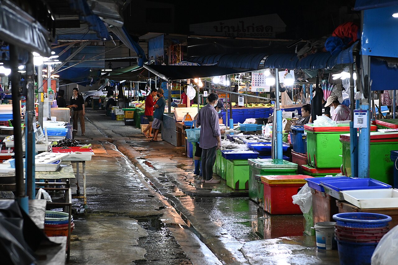 แผงขายของทะเลสดยามค่ำในย่านพัทยา ถังพลาสติกใส่ปลาและซีฟู้ดสดเรียงราย — บรรยากาศตลาดของทะเลแบบนาเกลือและลานโพธิ์
