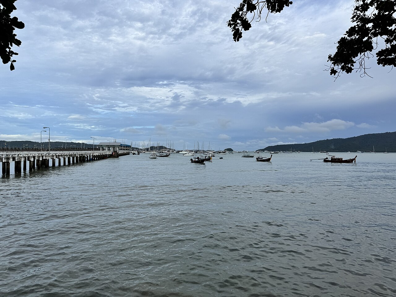 Chalong Pier in Phuket with boats and the sea — an area with long-running waterfront seafood restaurants