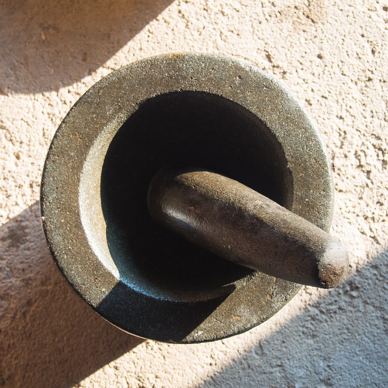 A stone mortar and pestle for pounding Thai curry paste, the main tool for the make-your-own-curry-paste step that many people enjoy most in a cooking class