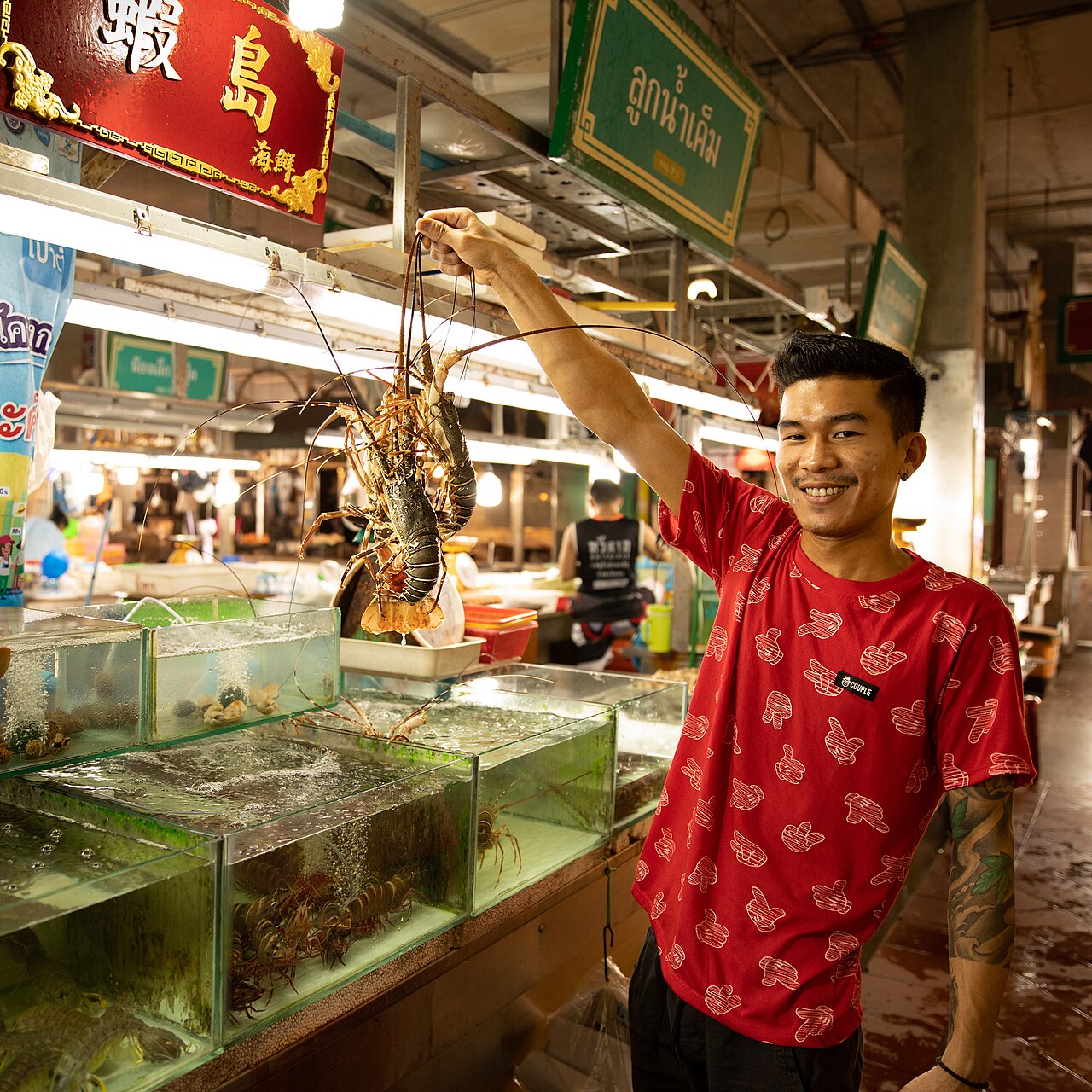 Fresh spiny lobsters lined up for sale at a seafood market stall — a premium pick in Phuket