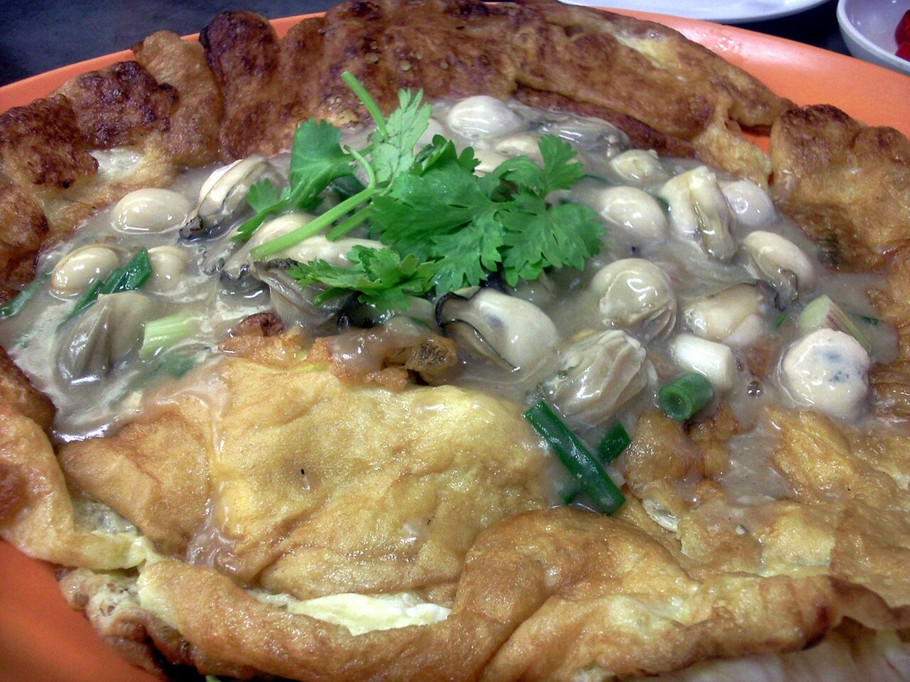 ออส่วนหอยทอด หอยนางรมทอดกับไข่และแป้ง โรยต้นหอมและผักชี รสกรอบนอกนุ่มใน