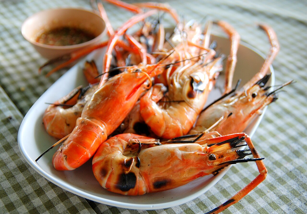 Grilled prawns on a plate served with a spicy seafood dip — a popular seafood order at Rawai, Phuket