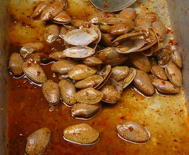 Clams stir-fried with roasted chilli paste and basil — a punchy Thai shellfish dish found at Phuket seafood restaurants
