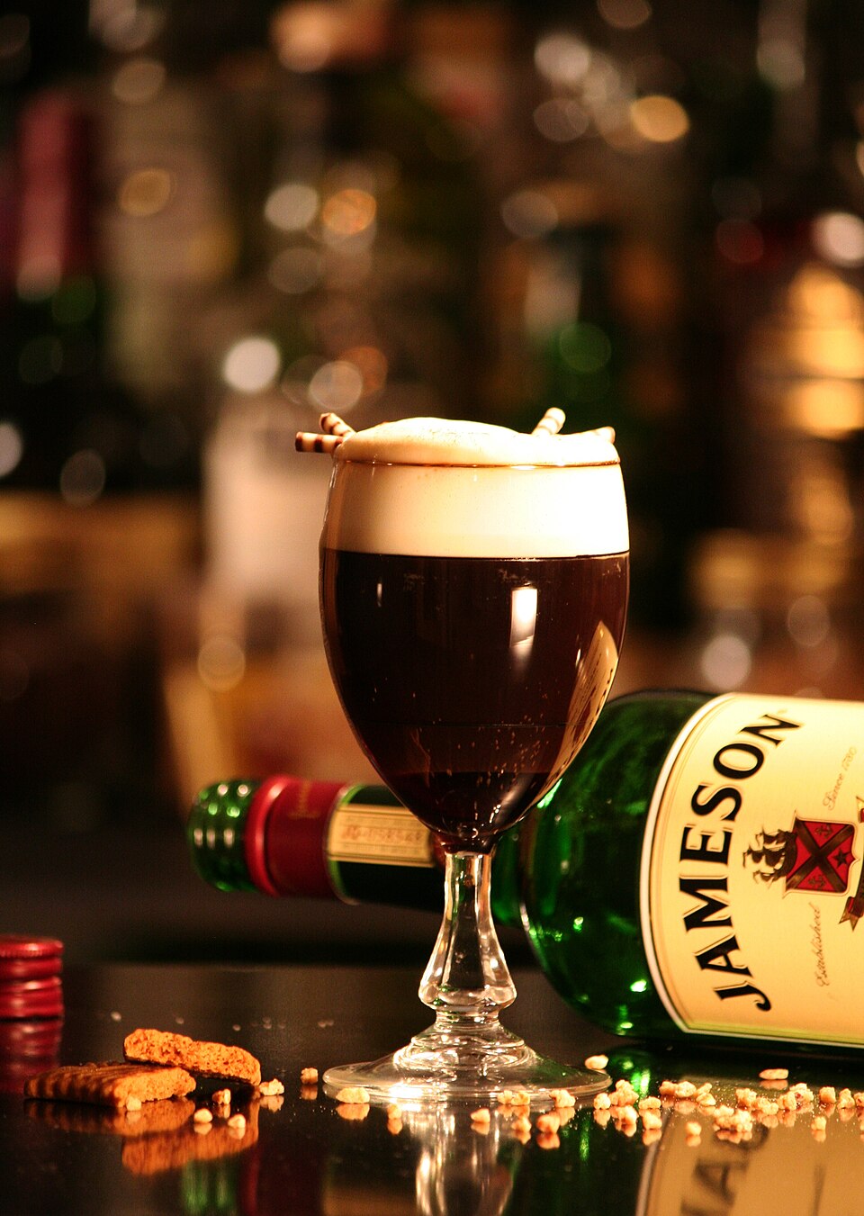Irish coffee with whiskey topped with whipped cream in a clear glass