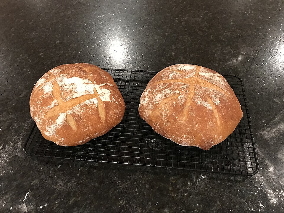 A round sourdough bread loaf with a hard golden-brown crust
