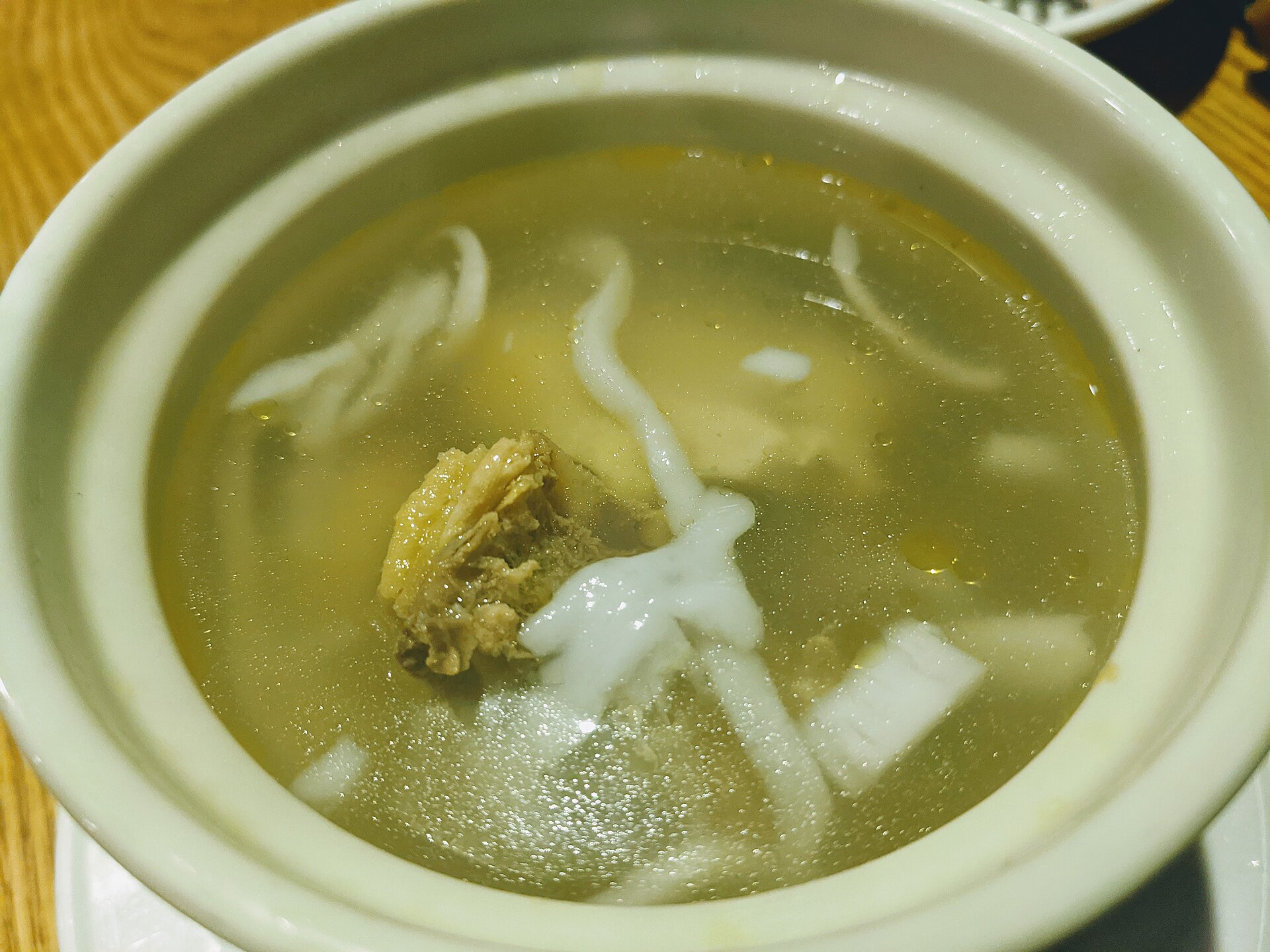 หม้อไฟไก่น้ำมะพร้าวในหม้อดิน ซุปน้ำมะพร้าวอ่อนใสกับไก่บ้าน วางคู่จานเนื้อมะพร้าวและน้ำจิ้มข่าทราย