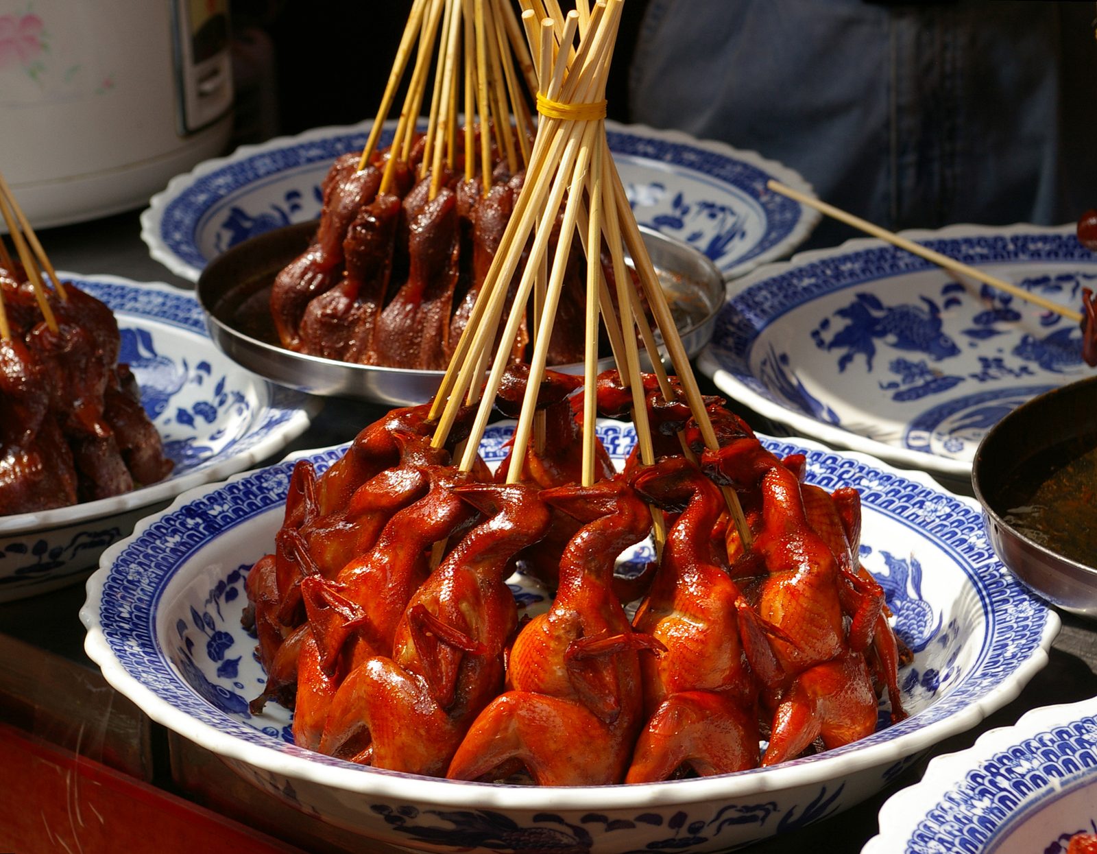 อาหารแบบเสียบไม้ที่ตลาดซีเป่า เซี่ยงไฮ้ — นกเสียบไม้ราดน้ำปรุงในชามเซรามิกน้ำเงินขาว