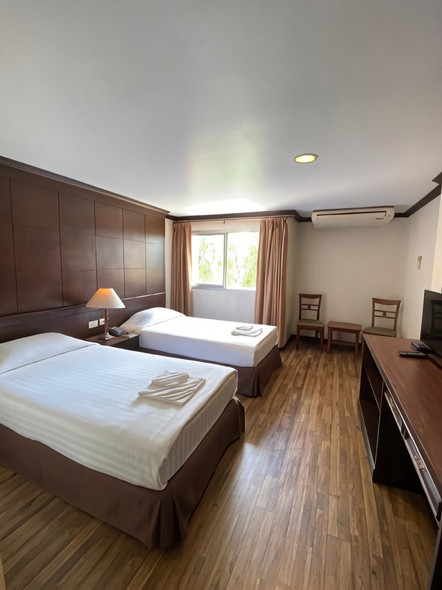 Twin room with warm wood walls and wooden flooring, air-conditioned