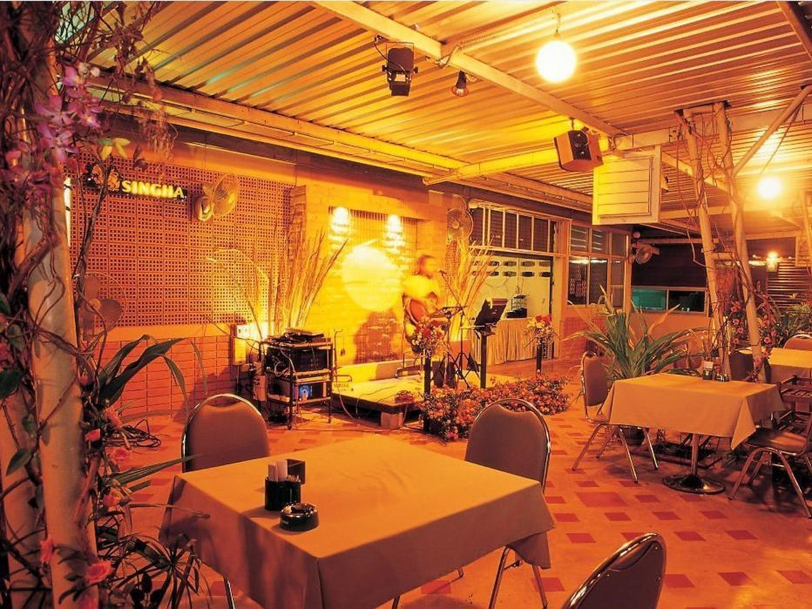 Open-air garden restaurant at night with set tables and live music