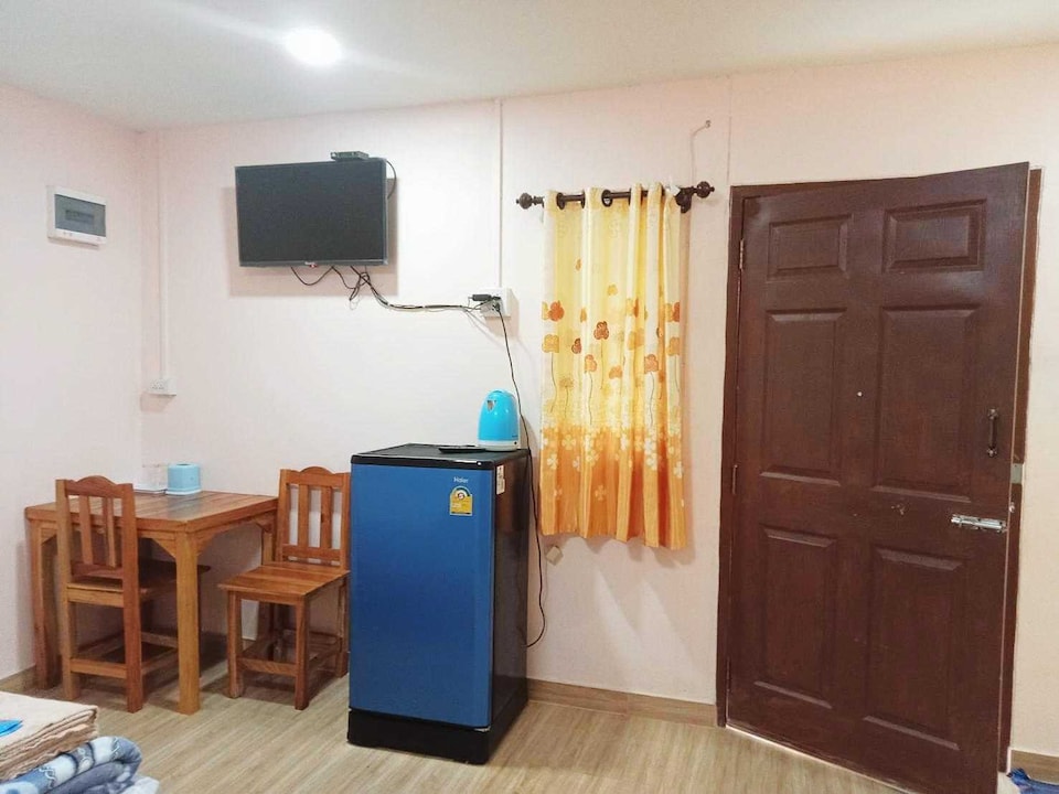 ห้องพักของ Leelawadee View Resort มีทีวีติดผนัง ตู้เย็น โต๊ะไม้และเก้าอี้