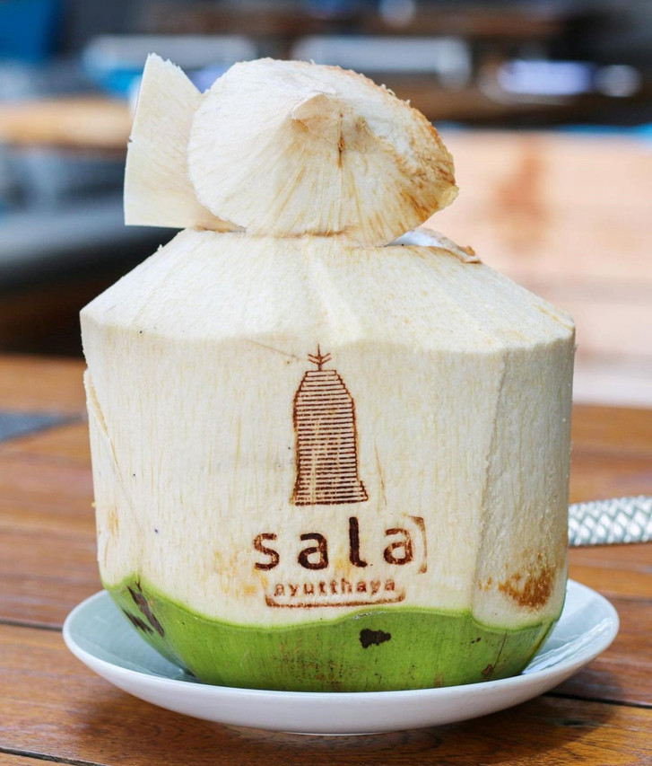 Fresh coconut branded with the sala ayutthaya logo at the riverside restaurant